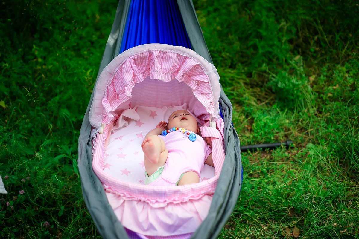 Bébé dans hamaca rose sur l'herbe Bébé dans hamaca rose sur l'herbe