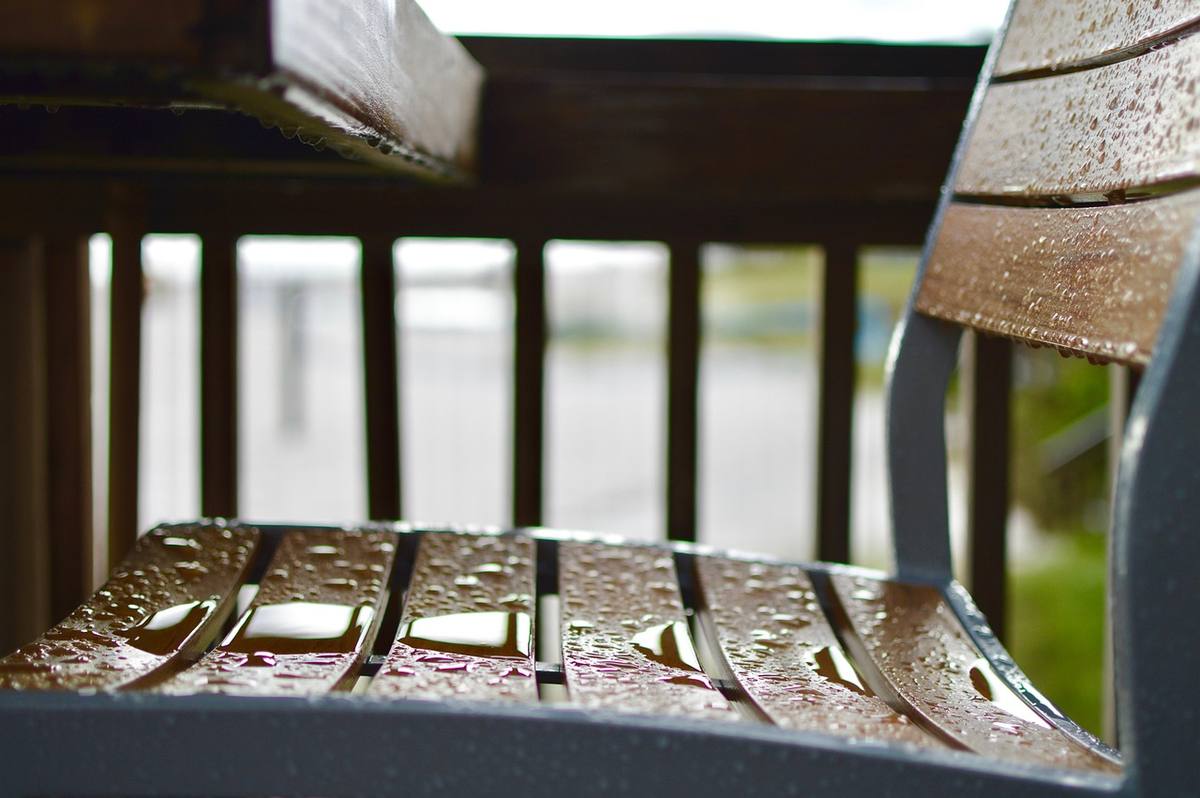 Table et chaises de jardin mouillées sur une terrasse après la pluie