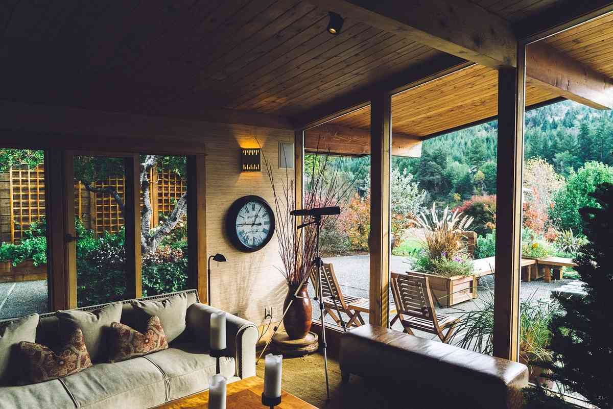 Véranda intérieure avec meubles et vue sur jardin extérieur