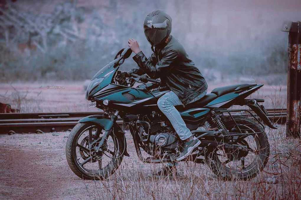 Personne en moto sur une route déserte, champ à l'arrière-plan Personne en moto sur une route déserte, champ à l'arrière-plan