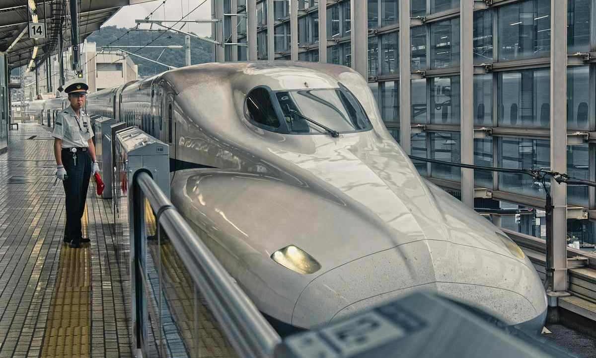 Train de passagers blanc brillant en gare, voyageur sur le quai