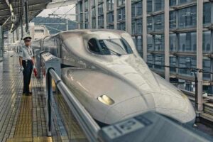 Train de passagers blanc brillant en gare, voyageur sur le quai
